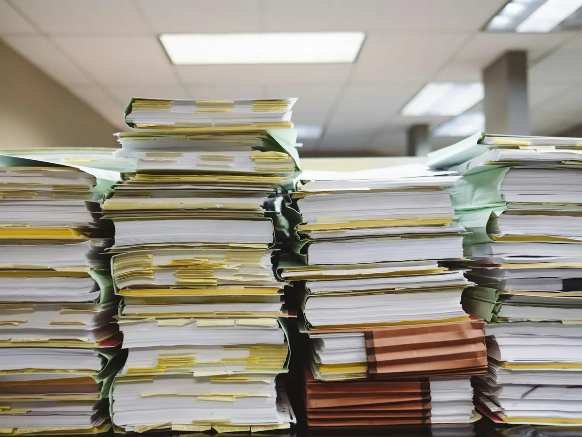 Piles de dossiers papier dans un bureau